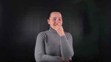 Genç ve güzel bir kadın gergin bir şekilde tırnaklarını yiyor, siyah bir zeminde huzursuzca kayıyor. İç karışıklığı, yoğun bir sıkıntı araştırması, tedirgin vücudundan aşikar hale geldi.