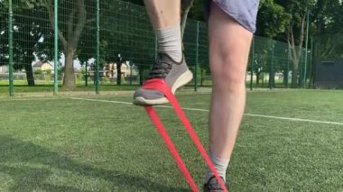 Spor giyim sektöründe genç bir adam sabah spor sahasında spor aleti kullanarak spor yapıyor. Forma olan bağlılığı odaklanma ve enerjiyle eğitim rutinini gerçekleştiriyor.
