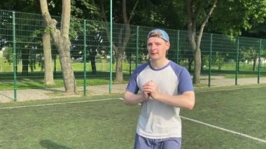 Spor giyim sektöründe genç bir adam sabah spor sahasında spor aleti kullanarak spor yapıyor. Forma olan bağlılığı odaklanma ve enerjiyle eğitim rutinini gerçekleştiriyor.