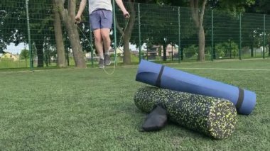 Spor giyim sektöründe genç bir adam sabah spor sahasında spor aleti kullanarak spor yapıyor. Forma olan bağlılığı odaklanma ve enerjiyle eğitim rutinini gerçekleştiriyor.