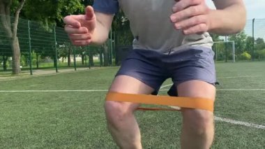 Spor giyim sektöründe genç bir adam sabah spor sahasında spor aleti kullanarak spor yapıyor. Forma olan bağlılığı odaklanma ve enerjiyle eğitim rutinini gerçekleştiriyor.