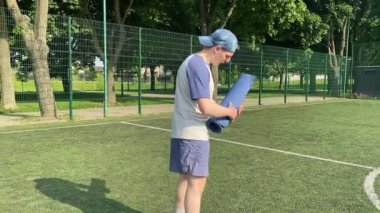 Spor giyim sektöründe genç bir adam sabah spor sahasında spor aleti kullanarak spor yapıyor. Forma olan bağlılığı odaklanma ve enerjiyle eğitim rutinini gerçekleştiriyor.