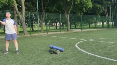 Spor giyim sektöründe genç bir adam sabah spor sahasında spor aleti kullanarak spor yapıyor. Forma olan bağlılığı odaklanma ve enerjiyle eğitim rutinini gerçekleştiriyor.