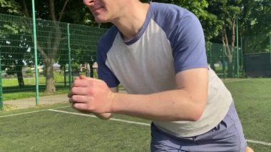 Spor giyim sektöründe genç bir adam sabah spor sahasında spor aleti kullanarak spor yapıyor. Forma olan bağlılığı odaklanma ve enerjiyle eğitim rutinini gerçekleştiriyor.