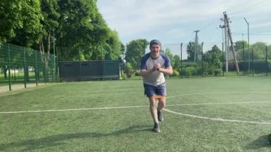 Spor giyim sektöründe genç bir adam sabah spor sahasında spor aleti kullanarak spor yapıyor. Forma olan bağlılığı odaklanma ve enerjiyle eğitim rutinini gerçekleştiriyor.