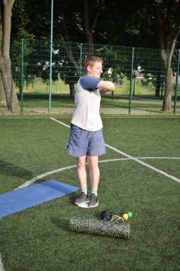 Spor giyim sektöründe genç bir adam sabah spor sahasında spor aleti kullanarak spor yapıyor. Forma olan bağlılığı odaklanma ve enerjiyle eğitim rutinini gerçekleştiriyor.