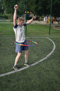 Spor giyim sektöründe genç bir adam sabah spor sahasında spor aleti kullanarak spor yapıyor. Forma olan bağlılığı odaklanma ve enerjiyle eğitim rutinini gerçekleştiriyor.