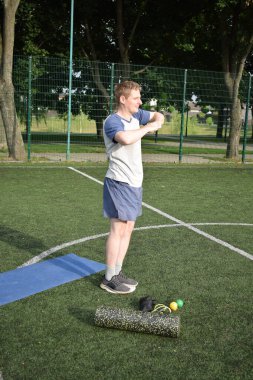 Spor giyim sektöründe genç bir adam sabah spor sahasında spor aleti kullanarak spor yapıyor. Forma olan bağlılığı odaklanma ve enerjiyle eğitim rutinini gerçekleştiriyor.