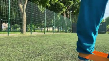 Odaklanmış genç bir bayan atlet dinamik bir şekilde ısınma egzersizleri yapıyor ve dışarıda esniyor. Spor giyim sektöründe bedenini düzenli bir rutin içinde fiziksel taleplere özenle hazırlar.