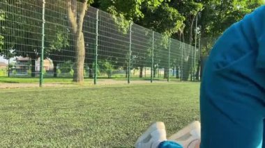 Odaklanmış genç bir bayan atlet dinamik bir şekilde ısınma egzersizleri yapıyor ve dışarıda esniyor. Spor giyim sektöründe bedenini düzenli bir rutin içinde fiziksel taleplere özenle hazırlar.