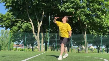 Spor giyim sektöründe genç bir adam sabah bir spor sahasında badminton oynuyor. Spor için adanmışlık ve tutku, sabah egzersizinin özü ve açık havada pratik.