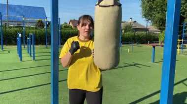 Spor giyim sektöründe genç bir kadın spor yapıyor, spor aletini sabahları spor sahasında fiziksel egzersiz için kullanıyor. Forma olan bağlılığı odaklanma ve enerjiyle eğitim rutinini gerçekleştiriyor.