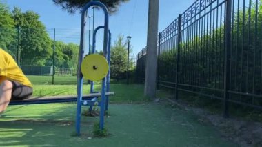 Spor giyim sektöründe genç bir kadın spor yapıyor, spor aletini sabahları spor sahasında fiziksel egzersiz için kullanıyor. Forma olan bağlılığı odaklanma ve enerjiyle eğitim rutinini gerçekleştiriyor.
