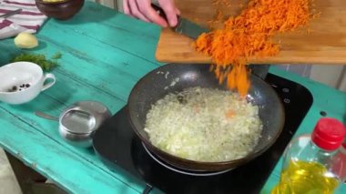 Mutfak konsepti, ev yapımı yemekler için hazırlama malzemeleri. Önlüklü genç bir adam ev mutfağında sebze sote yaparak yemek hazırlıyor. Ev yemeği ve aşçılık tutkusu