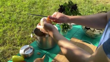 Yakışıklı bir beyaz adam açık hava barbeküsü için malzeme hazırlıyor. Açık ateşte leziz bir yemek. Bahçede yemek pişirmenin rahatlatıcı atmosferine sahip olmanın keyfi. BBQ konsepti