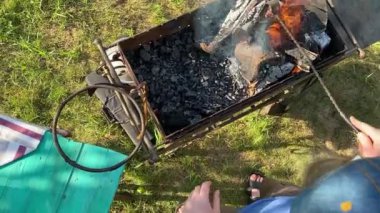 Yakışıklı bir beyaz adam açık hava barbeküsü için malzeme hazırlıyor. Açık ateşte leziz bir yemek. Bahçede yemek pişirmenin rahatlatıcı atmosferine sahip olmanın keyfi. BBQ konsepti