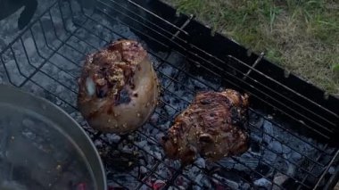 Yakışıklı beyaz bir adam arka bahçedeki ızgarada yemek hazırlıyor, açık hava yemeklerinin tadını çıkarıyor. Et ızgarası üzerine yoğunlaşıyor. Ev ortamında rahatça yemek pişirme becerileri. BBQ konsepti