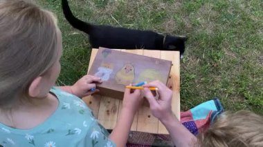 Genç bir baba ve kızı arka bahçede evcil kemirgenlerle ilgilenerek birlikte kaliteli vakit geçirmenin keyfini çıkarıyorlar. Aile ve çocuk, küçük hayvanlarına sevgi dolu bir şekilde açık hava ortamında bakıyorlar.