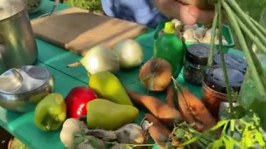 Yakışıklı bir beyaz adam açık hava barbeküsü için malzeme hazırlıyor. Açık ateşte leziz bir yemek. Bahçede yemek pişirmenin rahatlatıcı atmosferine sahip olmanın keyfi. BBQ konsepti