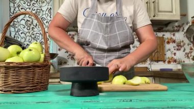 Genç ve çekici bir ev hanımı sıcak mutfağında ev yapımı elmalı turta hazırlıyor. Çekici kadın hamur mayası ve elma dolgusu ile geleneksel pişirme yöntemlerini vurgulayarak ustalıkla çalışıyor.