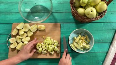 Genç ve çekici bir ev hanımı sıcak mutfağında ev yapımı elmalı turta hazırlıyor. Çekici kadın hamur mayası ve elma dolgusu ile geleneksel pişirme yöntemlerini vurgulayarak ustalıkla çalışıyor.