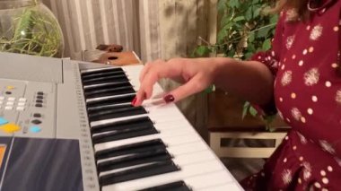 Şık elbiseli ve gözlüklü güzel bir genç kadın evde çalışırken bir müzik aleti çalar. İçeride yaratıcılığın ve adanmışlığın huzurlu bir anı. Hobi ve boş zaman