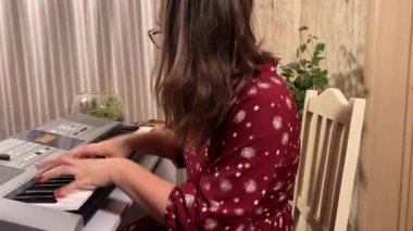 Şık elbiseli ve gözlüklü güzel bir genç kadın evde çalışırken bir müzik aleti çalar. İçeride yaratıcılığın ve adanmışlığın huzurlu bir anı. Hobi ve boş zaman