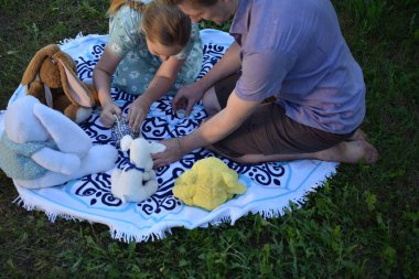 Genç bir baba çocuklarıyla dışarıda, bahçede, doldurulmuş hayvanlarla eğlenceli bir çay partisinde vakit geçirir. Sahnede aile bağları, hayal gücü ve neşe vurgulanıyor.
