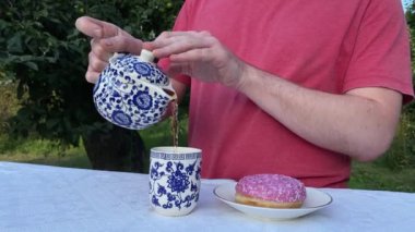 Genç bir adam ağaçlarla çevrili yemyeşil bir parkta gündelik bir öğle yemeğinin tadını çıkarıyor. Rahatlayarak ve yemeğin tadını çıkararak, temiz hava ve doğada biraz dinlenir.