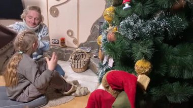 Genç bir baba ve çocuk, şöminenin başında rahat vakit geçirmenin keyfini çıkarırlar. Kış zamanının sıcaklığını ve konforunu kucaklarlar. Hygge konsepti. Aile bağları ve birlikte değerli anları paylaşıyorlar.