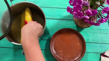 Lezzetli yemeklerle dolu kırsal bir yemek masası manzarası. Dişi eller yemeği hazırlar ve keyfini çıkarırlar. Kapalı mekanlar ev yapımı yemeklerin ve özenli yemeklerin neşesini ön plana çıkarıyor.