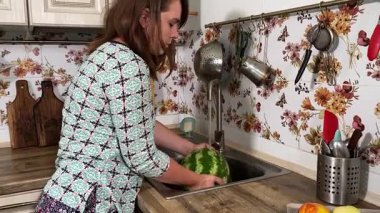 İçerideki sulu meyvelerin tadını çıkaran genç bir kadın taze ve sağlıklı tadını çıkarıyor. Rahatlamış ve memnun, sakin ve rahat bir atmosferde sağlıklı beslenmenin basit zevkini kucaklıyor..