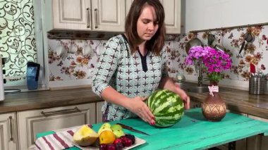 İçerideki sulu meyvelerin tadını çıkaran genç bir kadın taze ve sağlıklı tadını çıkarıyor. Rahatlamış ve memnun, sakin ve rahat bir atmosferde sağlıklı beslenmenin basit zevkini kucaklıyor..