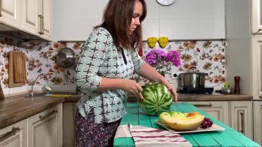 İçerideki sulu meyvelerin tadını çıkaran genç bir kadın taze ve sağlıklı tadını çıkarıyor. Rahatlamış ve memnun, sakin ve rahat bir atmosferde sağlıklı beslenmenin basit zevkini kucaklıyor..