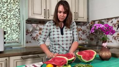 İçerideki sulu meyvelerin tadını çıkaran genç bir kadın taze ve sağlıklı tadını çıkarıyor. Rahatlamış ve memnun, sakin ve rahat bir atmosferde sağlıklı beslenmenin basit zevkini kucaklıyor..