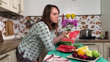 İçerideki sulu meyvelerin tadını çıkaran genç bir kadın taze ve sağlıklı tadını çıkarıyor. Rahatlamış ve memnun, sakin ve rahat bir atmosferde sağlıklı beslenmenin basit zevkini kucaklıyor..