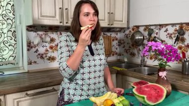 İçerideki sulu meyvelerin tadını çıkaran genç bir kadın taze ve sağlıklı tadını çıkarıyor. Rahatlamış ve memnun, sakin ve rahat bir atmosferde sağlıklı beslenmenin basit zevkini kucaklıyor..