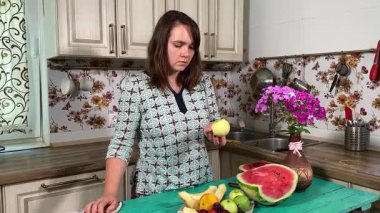 İçerideki sulu meyvelerin tadını çıkaran genç bir kadın taze ve sağlıklı tadını çıkarıyor. Rahatlamış ve memnun, sakin ve rahat bir atmosferde sağlıklı beslenmenin basit zevkini kucaklıyor..