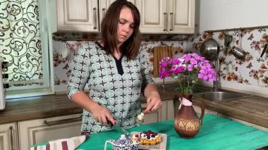 İçerideki genç bayan tatlı bir tart yiyip sıcak çay yudumluyor. Sıcak bir içecekle, sakin, rahat bir hoşgörü atmosferinde mükemmel bir şekilde eşleştirerek, zengin tatlı tadını çıkarıyor..