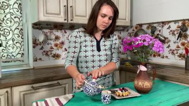 İçerideki genç bayan tatlı bir tart yiyip sıcak çay yudumluyor. Sıcak bir içecekle, sakin, rahat bir hoşgörü atmosferinde mükemmel bir şekilde eşleştirerek, zengin tatlı tadını çıkarıyor..