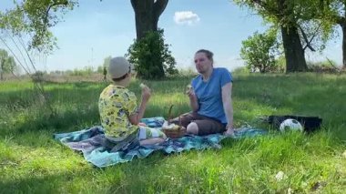 Küçük baba ve oğlu yaz pikniğinin tadını çıkarıyor, birlikte güzel vakit geçiriyorlar. Dışarıdaki eğlenceli aktivitelere katılıyorlar, sıcak güneşin altında mutlu anılar yaratıyorlar.