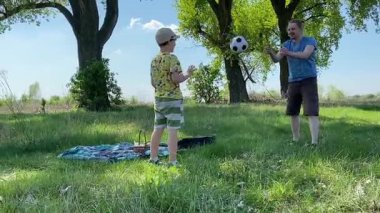 Küçük baba ve oğlu yaz pikniğinin tadını çıkarıyor, birlikte güzel vakit geçiriyorlar. Dışarıdaki eğlenceli aktivitelere katılıyorlar, sıcak güneşin altında mutlu anılar yaratıyorlar.