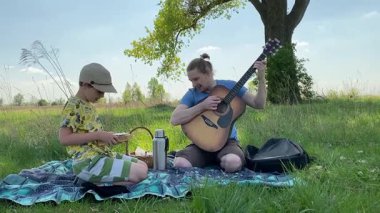 Küçük baba ve oğlu yaz pikniğinin tadını çıkarıyor, birlikte güzel vakit geçiriyorlar. Dışarıdaki eğlenceli aktivitelere katılıyorlar, sıcak güneşin altında mutlu anılar yaratıyorlar.