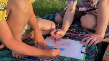 Küçük baba ve oğlu yaz pikniğinin tadını çıkarıyor, birlikte güzel vakit geçiriyorlar. Dışarıdaki eğlenceli aktivitelere katılıyorlar, sıcak güneşin altında mutlu anılar yaratıyorlar.