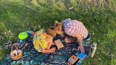 Küçük baba ve oğlu yaz pikniğinin tadını çıkarıyor, birlikte güzel vakit geçiriyorlar. Dışarıdaki eğlenceli aktivitelere katılıyorlar, sıcak güneşin altında mutlu anılar yaratıyorlar.