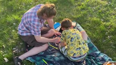 Küçük baba ve oğlu yaz pikniğinin tadını çıkarıyor, birlikte güzel vakit geçiriyorlar. Dışarıdaki eğlenceli aktivitelere katılıyorlar, sıcak güneşin altında mutlu anılar yaratıyorlar.