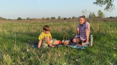 Küçük baba ve oğlu yaz pikniğinin tadını çıkarıyor, birlikte güzel vakit geçiriyorlar. Dışarıdaki eğlenceli aktivitelere katılıyorlar, sıcak güneşin altında mutlu anılar yaratıyorlar.