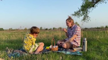 Küçük baba ve oğlu yaz pikniğinin tadını çıkarıyor, birlikte güzel vakit geçiriyorlar. Dışarıdaki eğlenceli aktivitelere katılıyorlar, sıcak güneşin altında mutlu anılar yaratıyorlar.