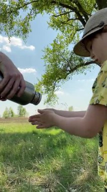 Dikey genç baba ve oğul yaz pikniğinin tadını çıkarıyor, birlikte güzel vakit geçiriyorlar. Dışarıdaki eğlenceli aktivitelere katılıyorlar, sıcak güneşin altında mutlu anılar yaratıyorlar.