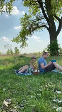 Dikey genç baba ve oğul yaz pikniğinin tadını çıkarıyor, birlikte güzel vakit geçiriyorlar. Dışarıdaki eğlenceli aktivitelere katılıyorlar, sıcak güneşin altında mutlu anılar yaratıyorlar.